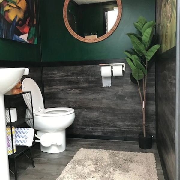 Modern bathroom with green walls and a large mirror.