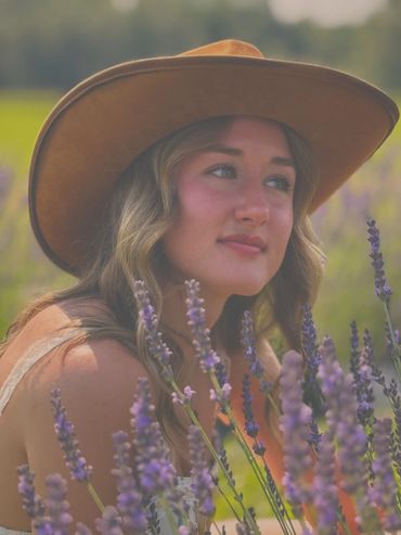 Woman wearing a brown hat in a lavender field.
