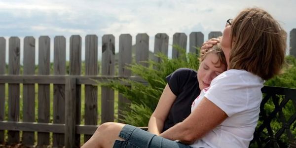 Picture of a woman holding a girl who is crying.