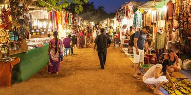 Evening market bustling with people shopping for clothes and footwear.