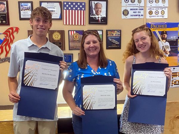 Three people holding award certificates.