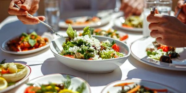 People enjoying a fresh salad meal together.