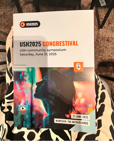 A programme booklet for USH2025 Congrestival on a lap.