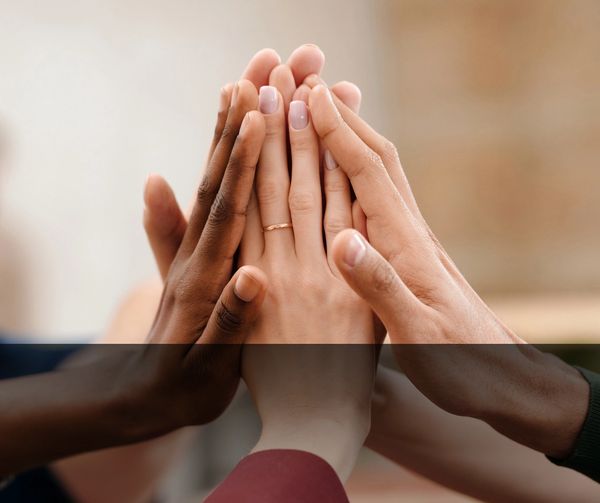 Several hands raised together in high 5.
