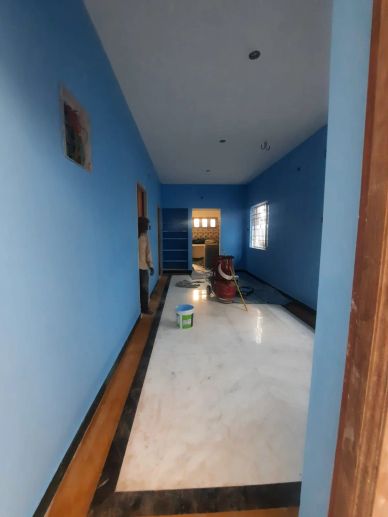 Room under renovation with blue walls and construction tools.