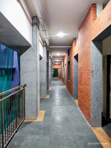 Empty corridor with brick walls and gray pillars.