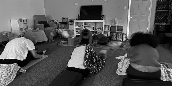 People doing yoga stretches indoors on mats.