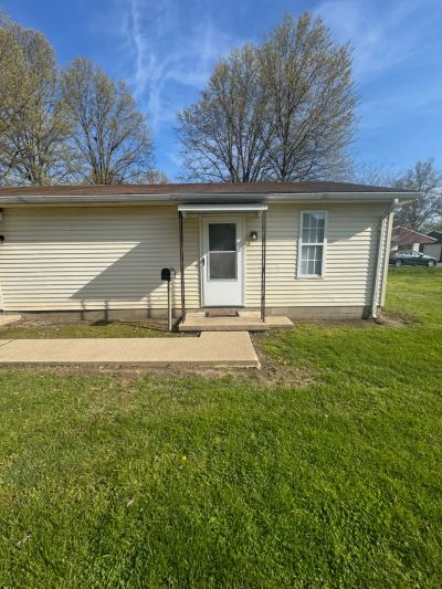 Small house exterior with a front door and porch.
