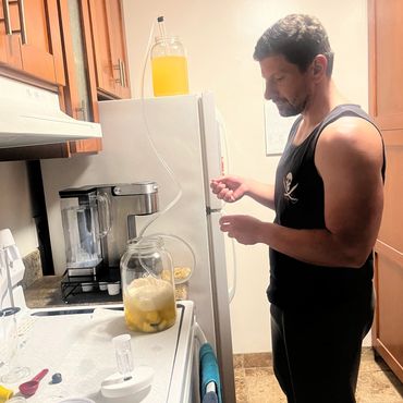 Richard transferring some mead into a carboy full of fruit