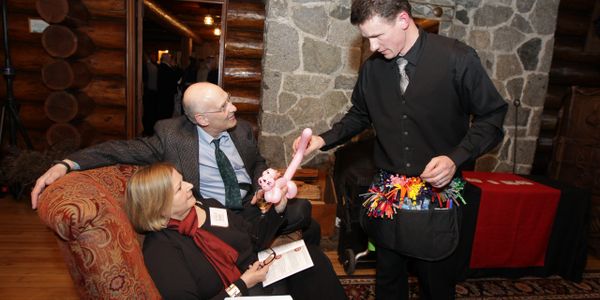 magican and balloon twister making balloon animals for adult aniversary wedding party