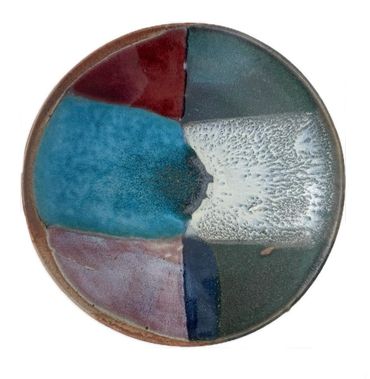 Round ceramic plate with multicolor glaze in sections.