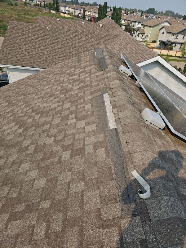 Wind damaged asphalt shingles on a Leduc, Alberta home before roof repair.
