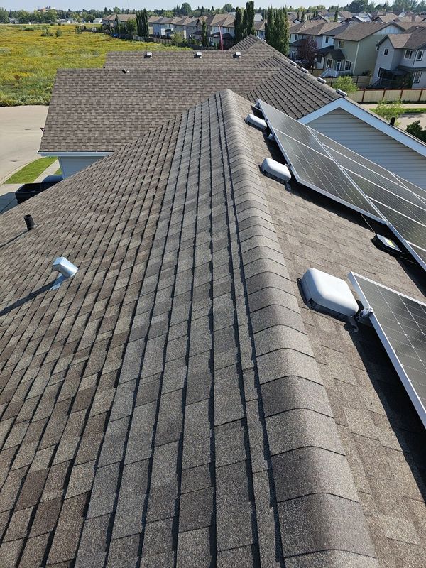 Completed roof repair with new shingles and ridge cap on Leduc home