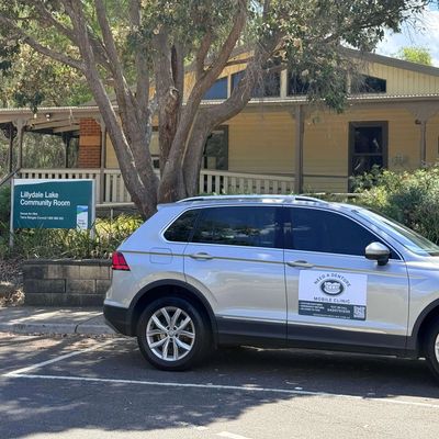 Silver SUV parked near Lillydale Lake Community Room with dental clinic signage.