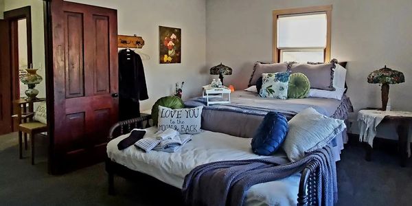 Cozy bedroom with vintage decor and layered bedding.