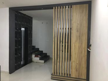 Modern interior with wooden partition and black textured wall near stairs.