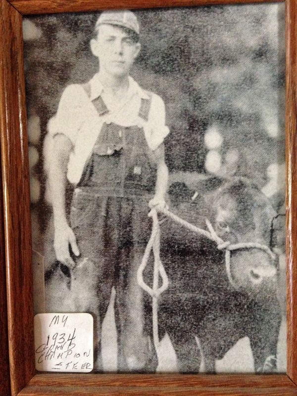 Black and white photo of a young man with a calf from 1934.