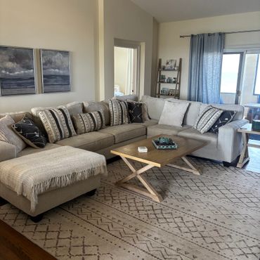 Cozy living room with beige sectional sofa and wooden coffee table.