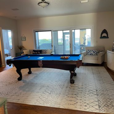 Cozy game room with a pool table and comfortable seating.