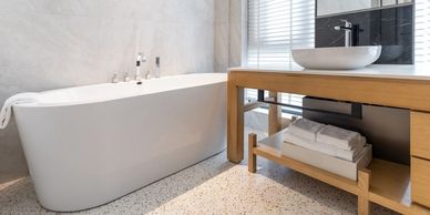 Modern bathroom with a freestanding bathtub and wooden vanity.