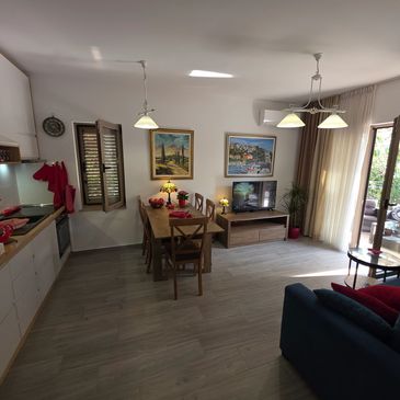 Cozy open kitchen and living area with wooden dining table and blue sofa.
