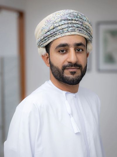Man wearing traditional Omani attire with a turban and white robe.