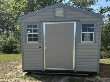 A gray outdoor storage shed with two windows and a central door.