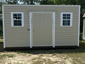 Small beige storage shed with two windows and a central door.