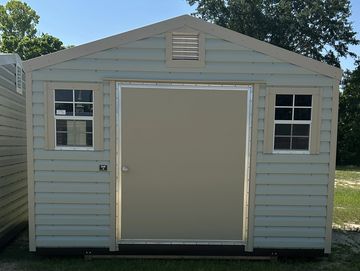 A beige storage shed with two windows and a central door.