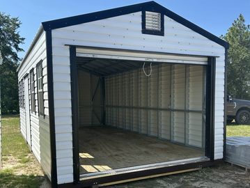 A metal garage shed with an open front in an outdoor setting.