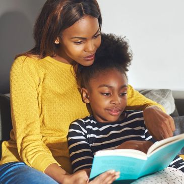 Mom reading a book with her daughter.