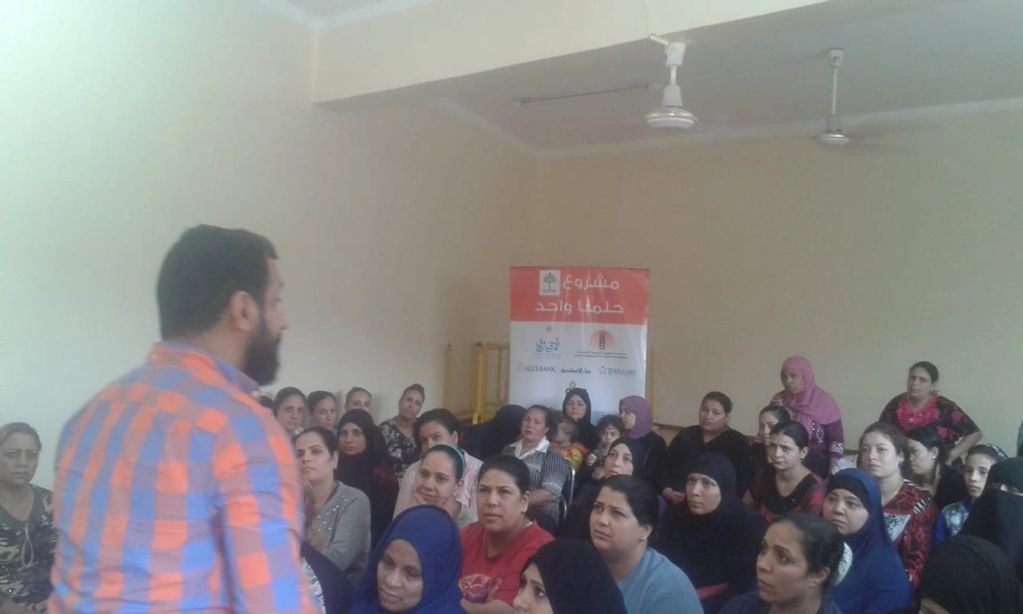 Man teaching literacy to a group of women.