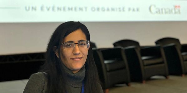 Woman in panel smiling at camera.