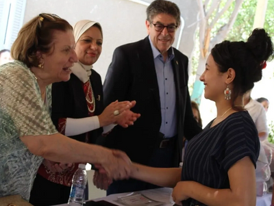 A woman cheerfully shaking hands.