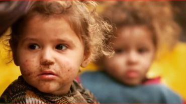 Two young children wearing dirty clothes