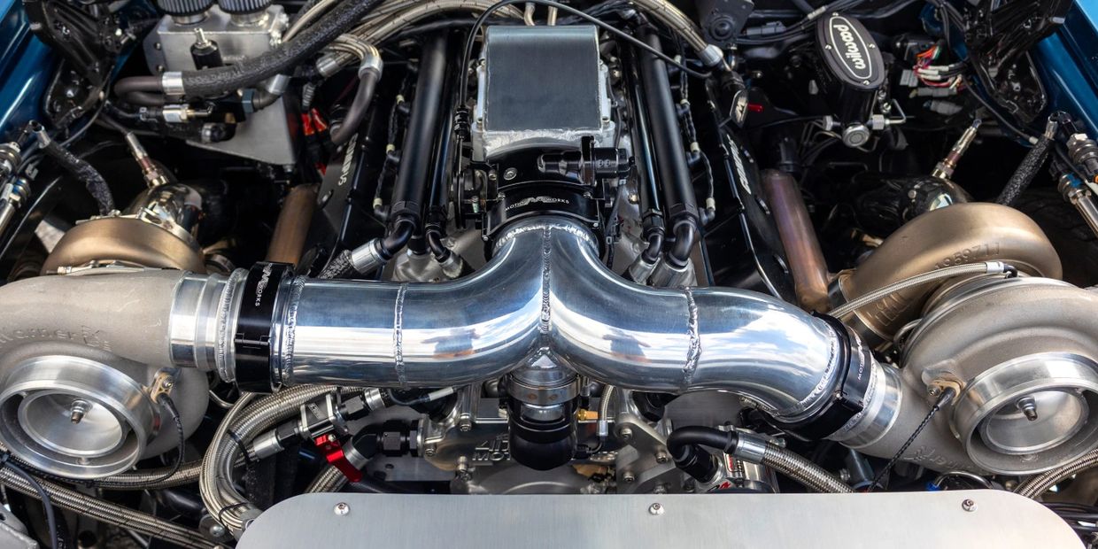 Close-up of a high-performance twin-turbo engine setup with polished pipes and intricate components.