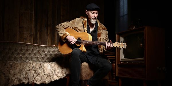 Marcus Schultz spielt auf einer Akustikgitarre