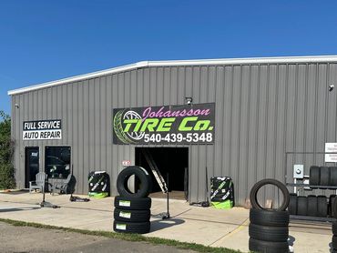 Exterior of Johansson Tire Co. with tires displayed outside under clear blue sky.
