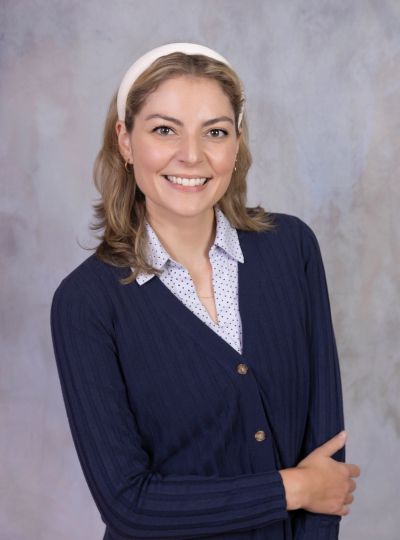Smiling woman with a navy cardigan and headband.