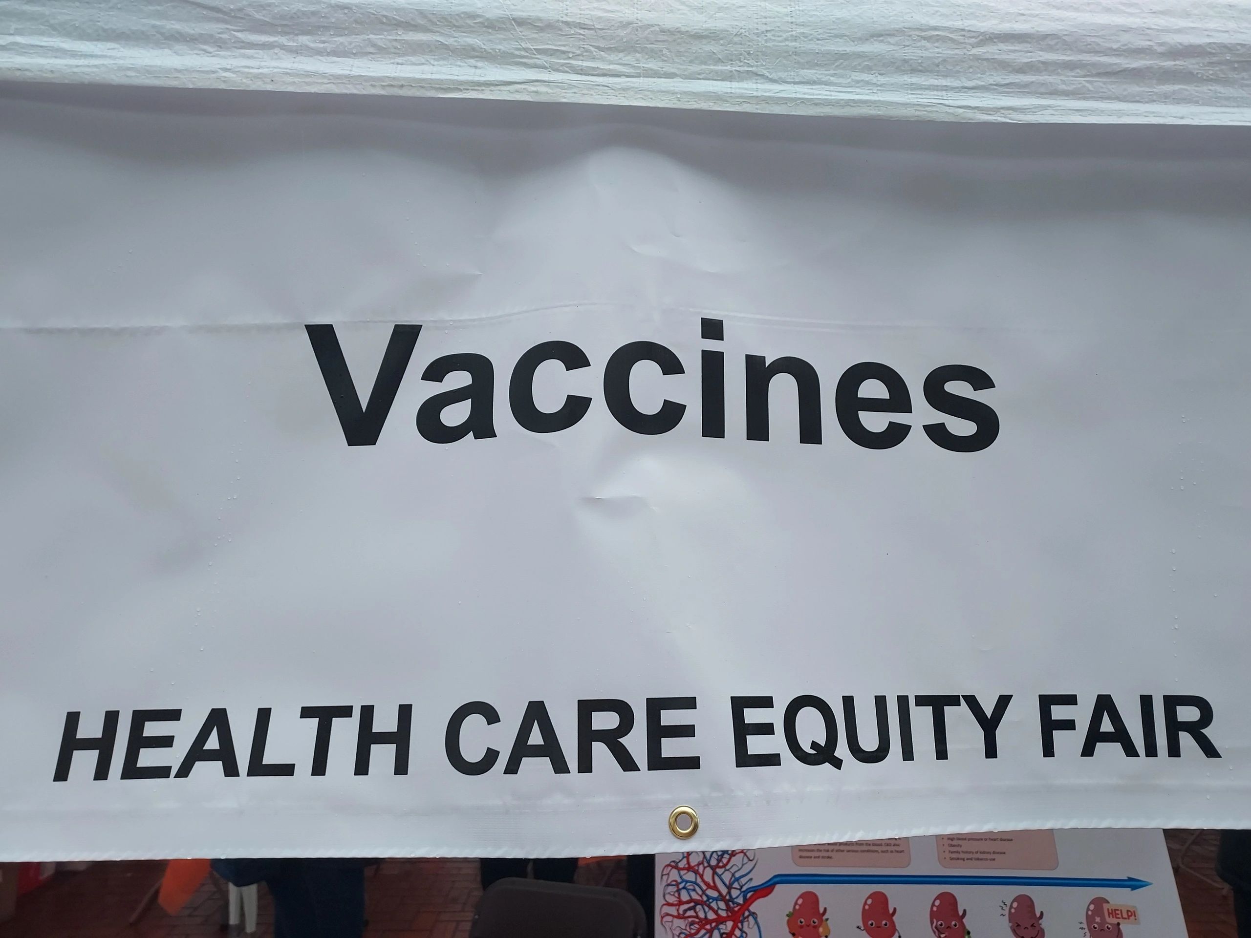 Banner promoting vaccines at a healthcare equity fair.