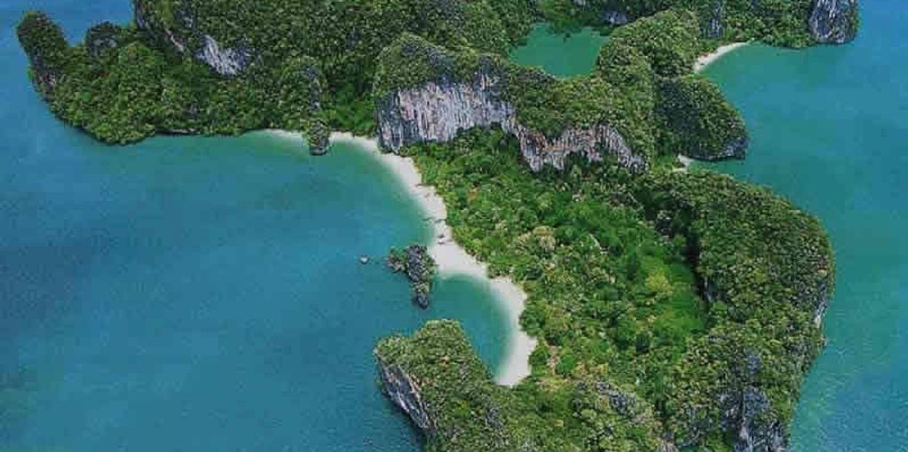 เกาะที่มีชายหาดและภูเขารายล้อมด้วยน้ำทะเลสีฟ้า