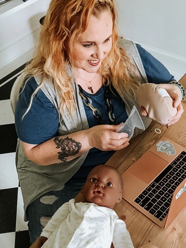 Caucasian female by a laptop computer using lactation supplies doing a virtual consultation.