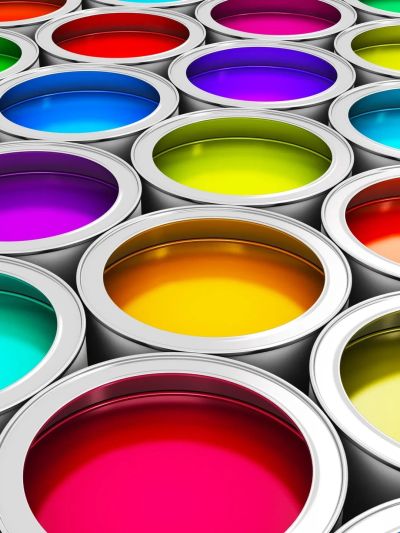 Open paint cans filled with vibrant colors arranged closely together.