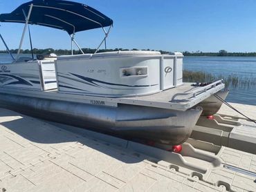 Pontoon with blue bimini up on Wave Armor Pontoon port tied up