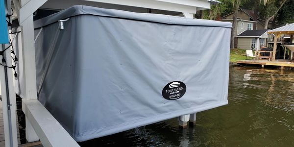 Touchless Boat Cover in Sea Gull Grey mounted under boat house on lake in Georgia 
