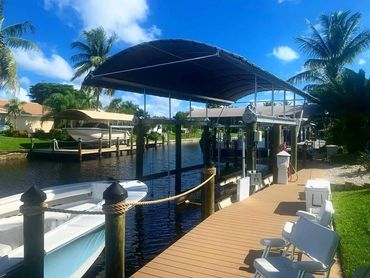 several Coastline Boatlift Covers installed over lifts on canal
