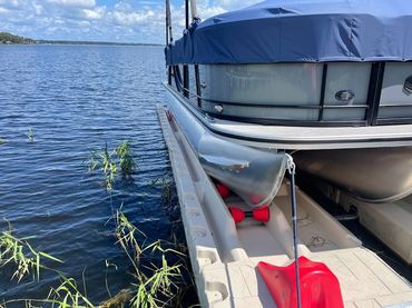 starboard side of tritoon shown with floating docks sections in the front, high water metal brackets