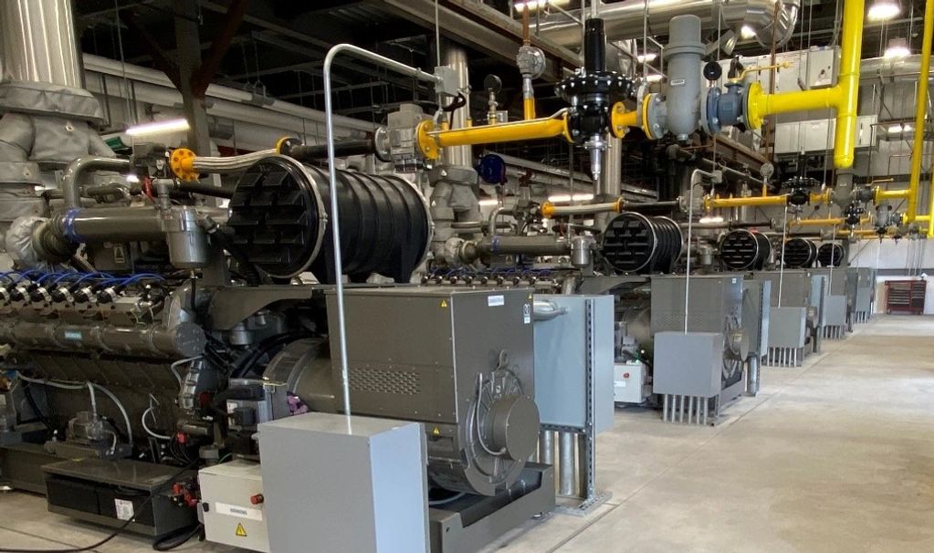 A row of industrial generators lined up in a factory setting.