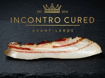 Cured slice of lard on a black surface.