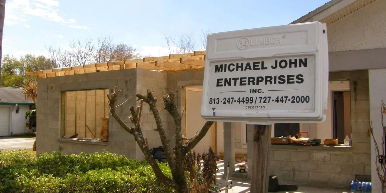 Signboard for Michael John Enterprises at a house under construction.